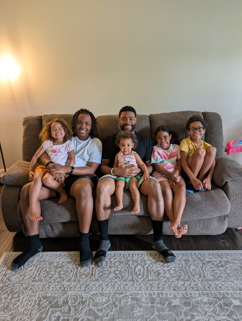 Cameron on the couch at home surrounded by his kids
