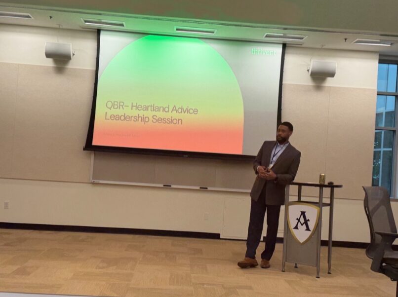Cameron presenting at a leadership session in front of a projected slide
